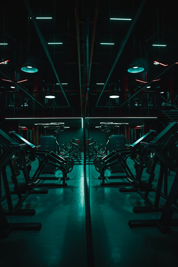 Mastering the First Impression: Your intriguing post title goes here Dark, atmospheric gym with mirrored weightlifting machines and neon lighting.